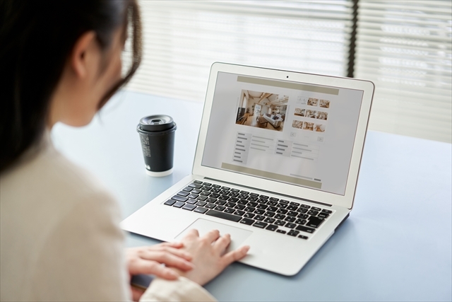 大手サイトの物件をパソコンで調査しているスタッフ